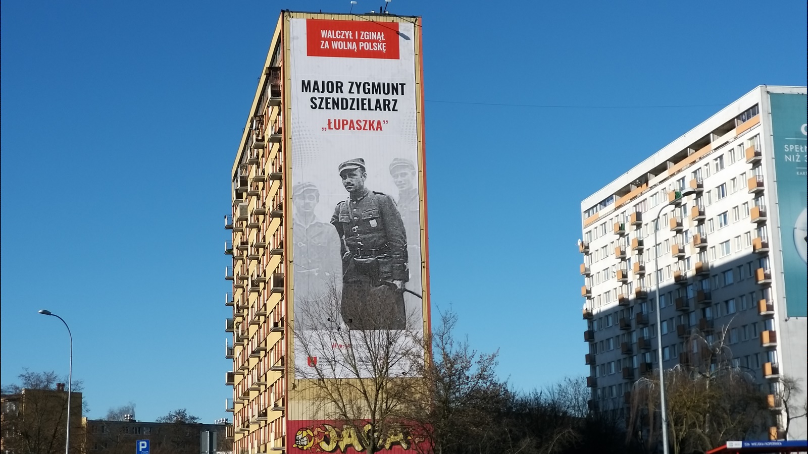 Baner z wizerunkiem "Łupaszki" na wieżowcu przy ul. Kopernika w Białymstoku